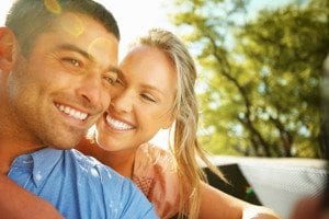 Couple Embracing Outdoors Under Sunlight