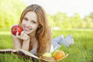 Female Eating an Apple Laying on Grass