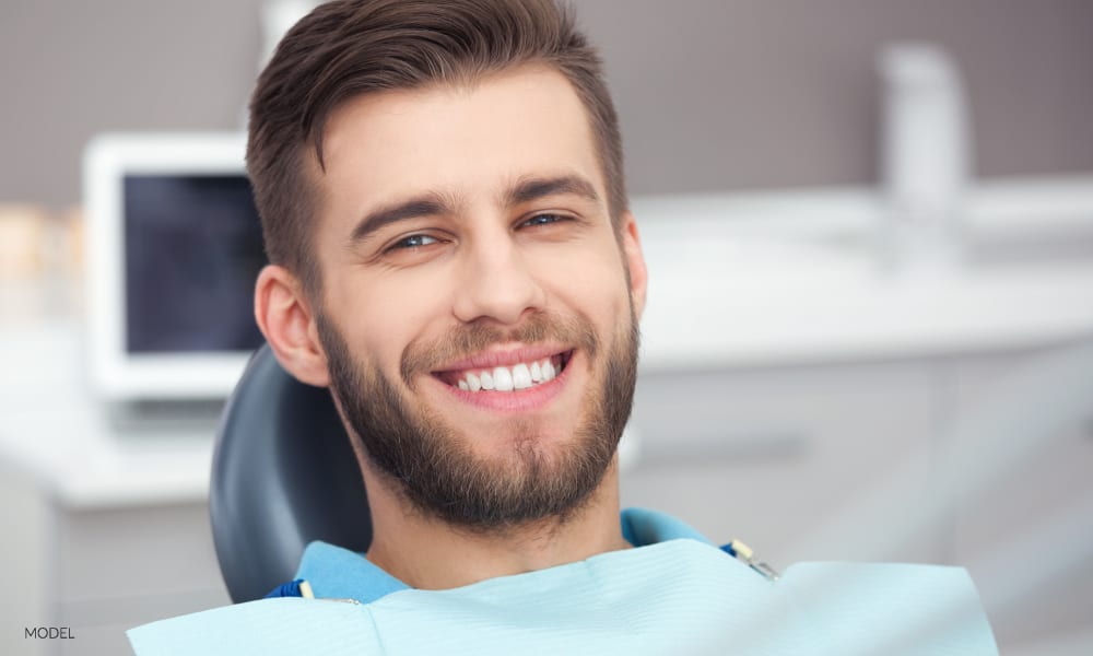 Young Male Smiling and Waiting for Wisdom Teeth Extraction in Dental Office Chair